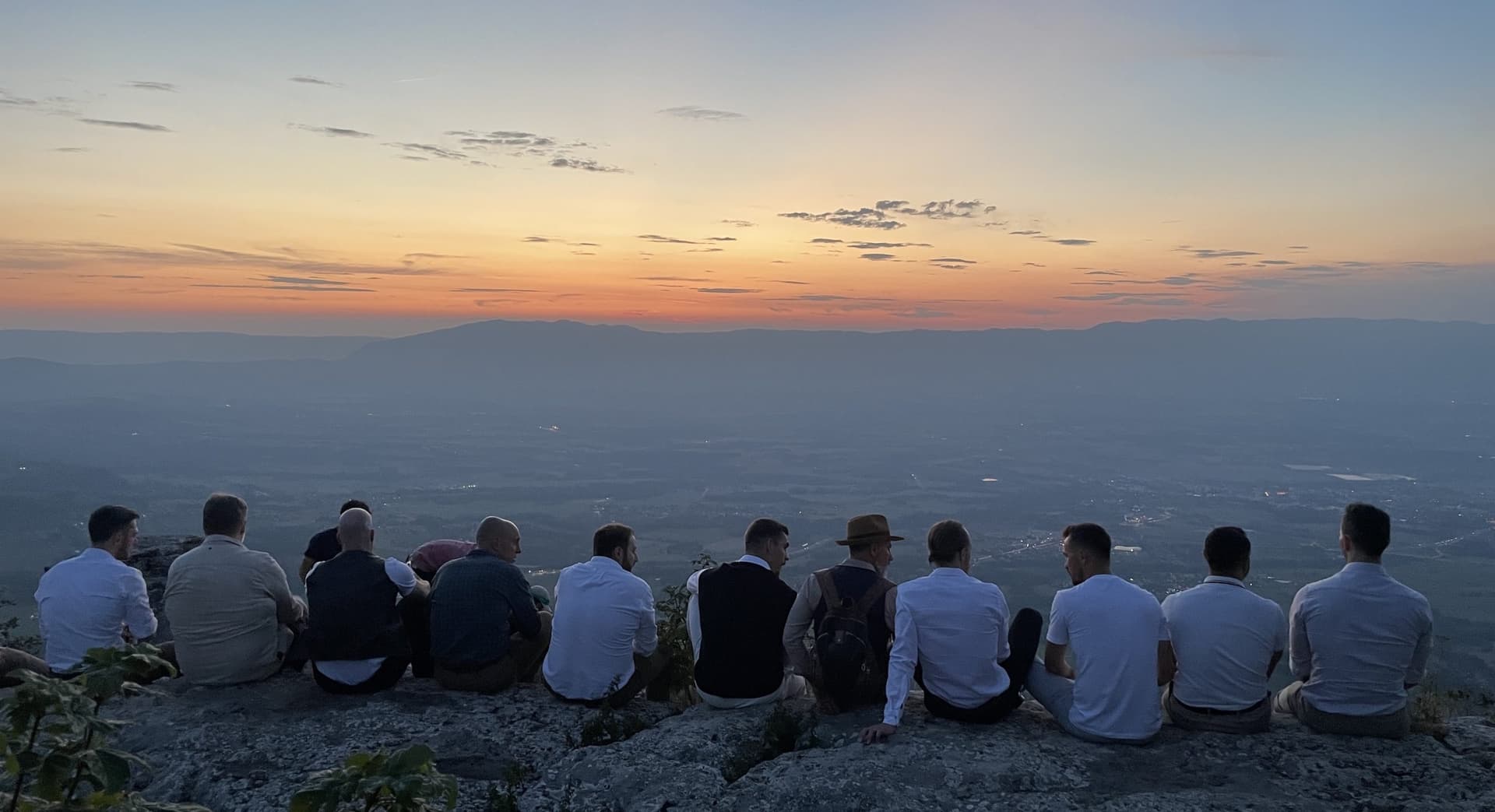 Men sitting together on a ridge at first light